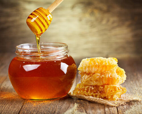 jar of honey with honeycomb on wooden table jar of honey with honeycomb on wooden table